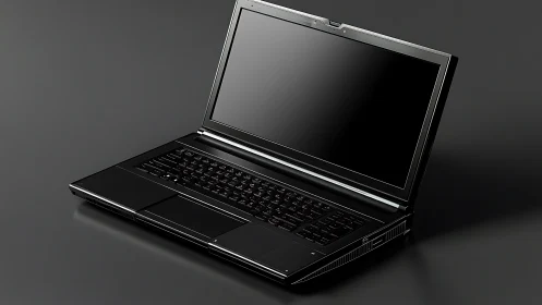 Sleek black laptop on dark reflective studio surface.