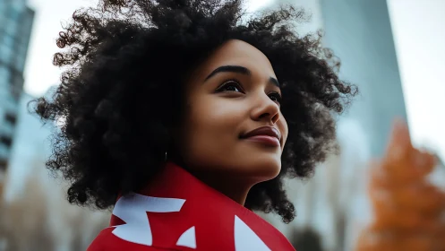 Confident young woman outdoors wrapped in red flag, modern style.