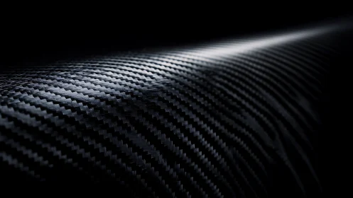 Curved carbon fiber surface with reflective woven texture.
