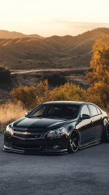 Midnight Chevy cruiser lounging under golden canyon sunset.