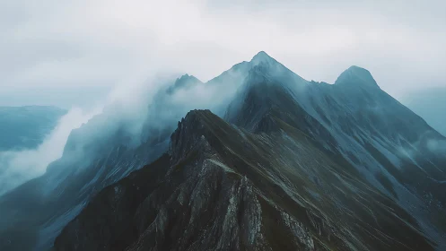Fog covered mountain ridge with layered distant peaks view.