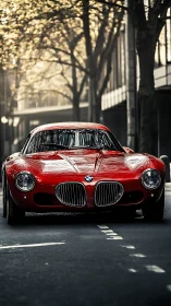 Crimson BMW coupe prowls a tree-lined city canyon at dawn