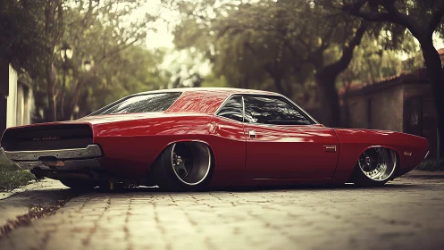 Red classic muscle car parked on quiet tree-lined street.