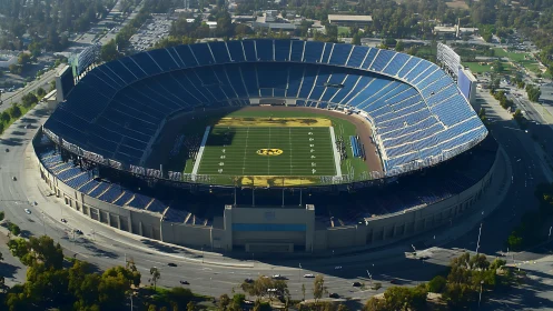 High-capacity open-air football stadium in aerial daylight view.