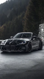 Black BMW sports coupe parked on mountain road in forest setting.