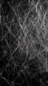 Scratched black surface with dense white linear marks.