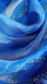 Blue translucent fabric folds with scattered gold accents.