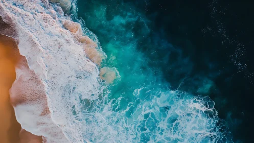 Shoreline brushstrokes trade sandy gold for deep teal seas