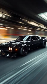 Black muscle car speeding through a blurred city tunnel.