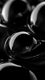 Glossy black liquid sphere reflects soft studio highlights