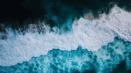 Aerial view of ocean surf forming white wave bands.