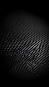 Dark perforated metal surface with deformed texture detail.
