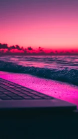 Neon sunset shoreline with laptop edge in foreground.