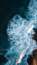 Ocean waves warmly embracing sunlit rocky shoreline.