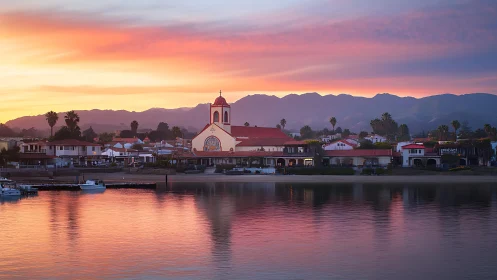 Coastal town waterfront with mission-style church at sunset