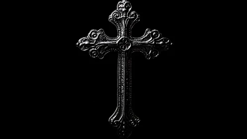 Ornate silver cross quietly shines against deep black space