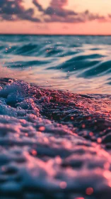 Sunlit ocean waves with close-up foam and droplets.