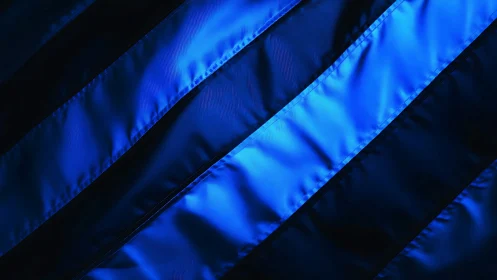 Diagonal blue fabric bands with contrasting dark gaps on black.