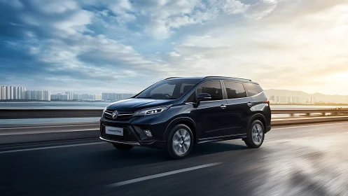 Black minivan travels on elevated highway by coastal city
