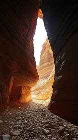 Narrow sandstone slot canyon with stratified walls and backlit exit