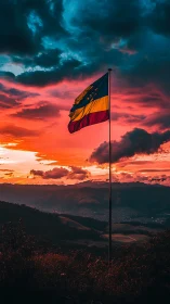 Sunset flag over misty hills in vivid stormy light.