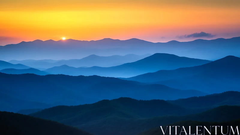 Layered blue mountain ridges under a minimal sunrise sky.