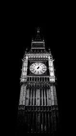 Monochrome clock tower rises starkly against midnight sky