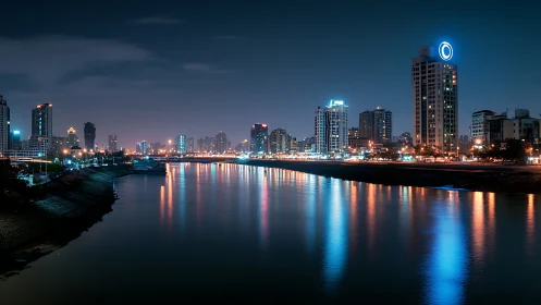 Neon riverfront skyline under deep blue nocturnal glow.