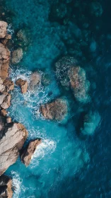 Aerial coastal interface with turbulent cyan wave dynamics.