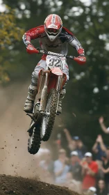 Motocross rider airborne over dirt track during race.
