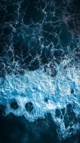 Turbulent teal ocean waves crash in foaming aerial view