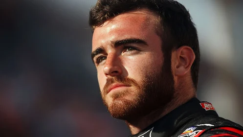 Sunlit close-up portrait isolates focused young racer&rsquo;s face