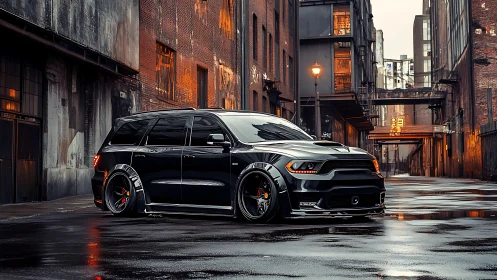 Black widebody SUV dominates wet industrial alley at dusk.