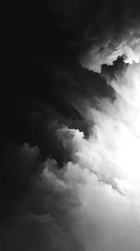 Monochrome storm clouds swirl toward a stark white light