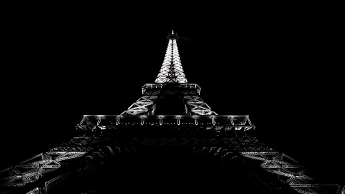 Steel tower structure is illuminated against a black sky