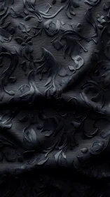 Ornate black jacquard fabric with raised floral arabesques.