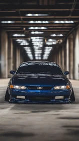 Sleek blue Chevrolet rests low and confident in a quiet tunnel