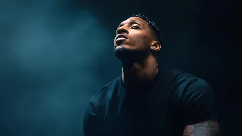 Moody portrait of man in upward gaze under cinematic light.