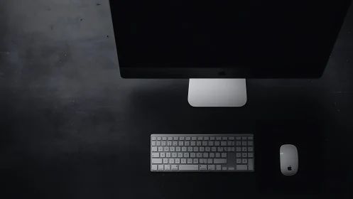 Overhead desktop workstation with Apple peripherals on black