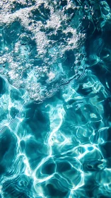 Sunlit pool water captures rising air bubbles in motion
