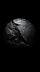 Fractured black sphere reveals rugged tectonic surface