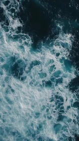 Turbulent ocean surface shows foaming white waves and dark water