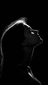 Silhouetted female profile in dramatic low key rim light.