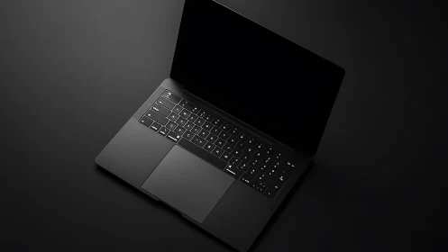 Sleek black laptop rests on dramatic dark background.