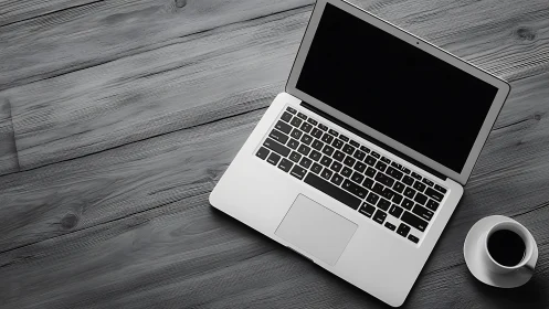 Quiet laptop and coffee inviting a calm workday moment.