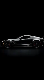 Side profile of black sports coupe on dark background.