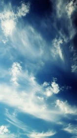 High-altitude cirrus clouds form streaked layers in blue sky