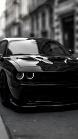 Black muscle car prowls a city street in moody focus.