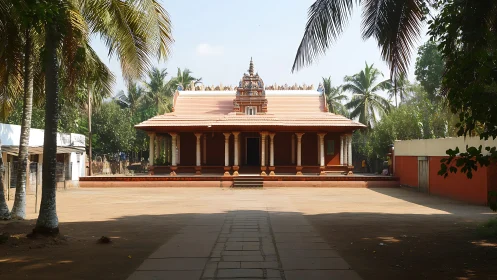 Traditional Hindu temple courtyard under palm trees.