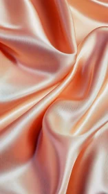Peach satin textile draped in fluid, high-gloss folds.